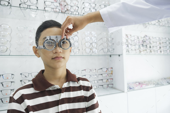 Young boy examining eyesight in optical clinic. - Stock Photo - Images