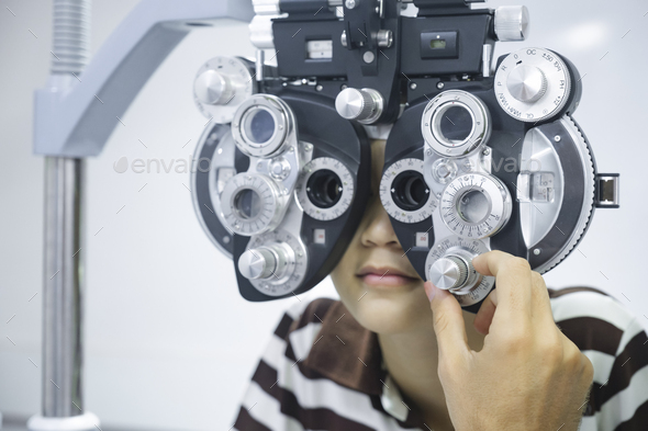 Young boy having eye test using phoropter. - Stock Photo - Images