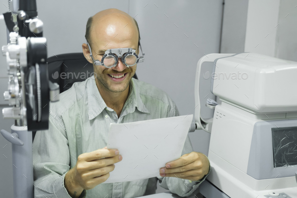 Man examining eyesight in optical clinic. - Stock Photo - Images