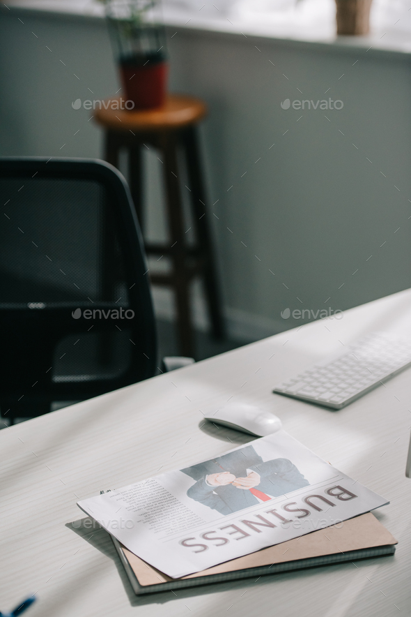 business newspaper and computer on tabletop in business office Stock Photo by LightFieldStudios