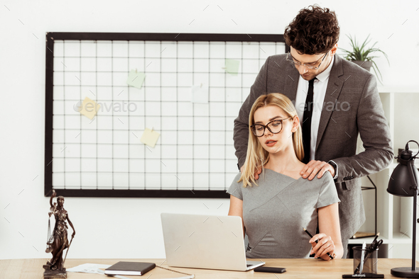 male lawyer making massage to colleague at workplace in office, flirt concept