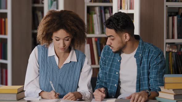 Students Do Homework in Library Teamwork Working on Joint Project Cute Girl Explaining Task to Male alt