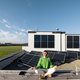 Woman meditates on rooftop of her house with solar power plant on background - PhotoDune Item for Sale