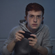 Focus caucasian teenage boy playing on game controller at night - PhotoDune Item for Sale