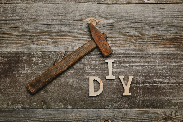 Top view of rusty hammer and diy sgn on wooden background - Stock Photo - Images