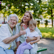 Worried senior grandmother comforting grown up granddaughter when sitting on bench in park, share - PhotoDune Item for Sale