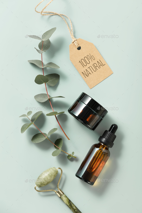 Minimal composition with cosmetic skin care products and eucalyptus leaves on pastel blue background - Stock Photo - Images