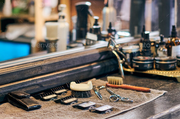Barbershop haircut tools barber equipment on wooden countertop front of mirror, old vintage interior