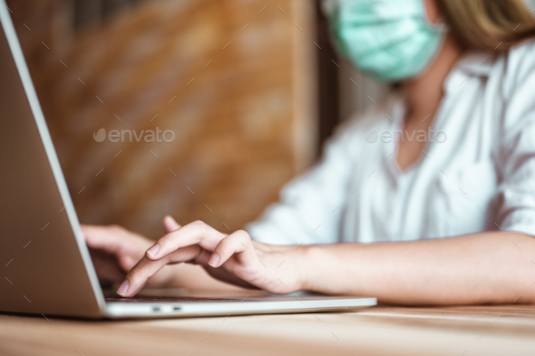 Woman work from home wearing mask protection wait for epidemic situation to improve soon at home.