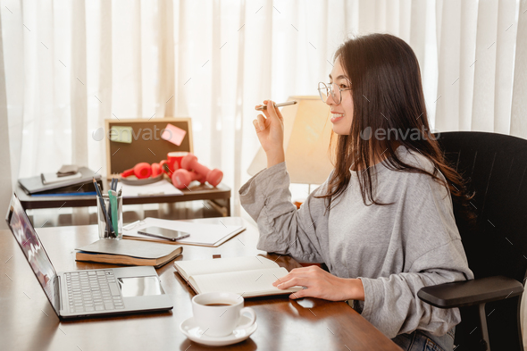 Woman work from home have a coffee cup beside wait epidemic situation to improve soon at home.