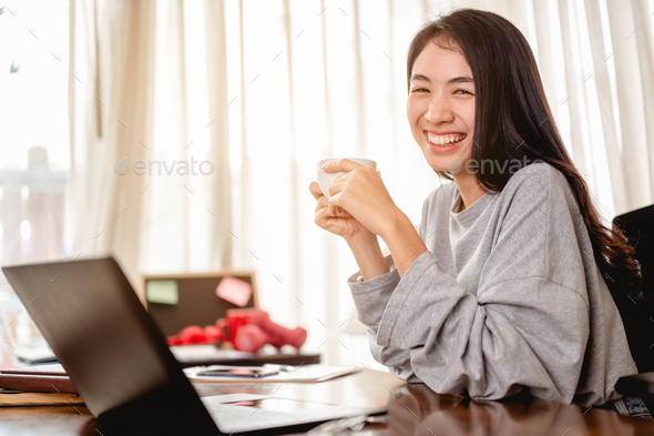 Woman holding a coffee cup work from home wait epidemic situation to improve soon at home.