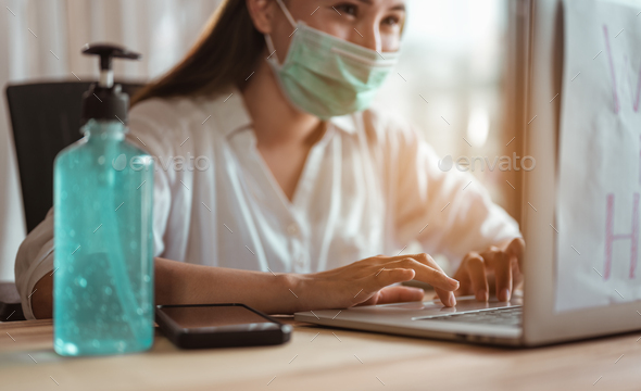 Woman work from home wearing mask protection wait for epidemic situation to improve soon at home.