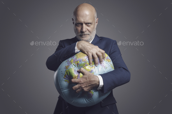 Greedy corporate businessman crushing and exploiting earth - Stock Photo - Images