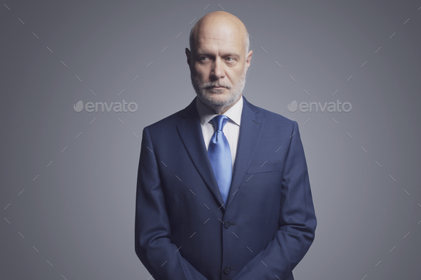 Pensive businessman portrait on gray backgorund - Stock Photo - Images
