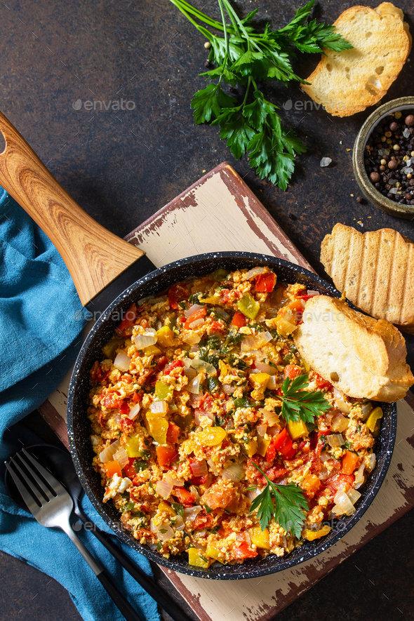 Menemen Scrambled eggs in a cast iron frying pan on a stone countertop. - Stock Photo - Images