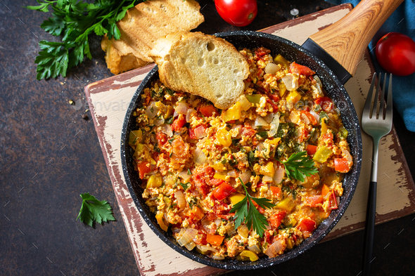 Turkish cuisine. Menemen Scrambled eggs in a cast iron frying pan on a stone countertop. - Stock Photo - Images
