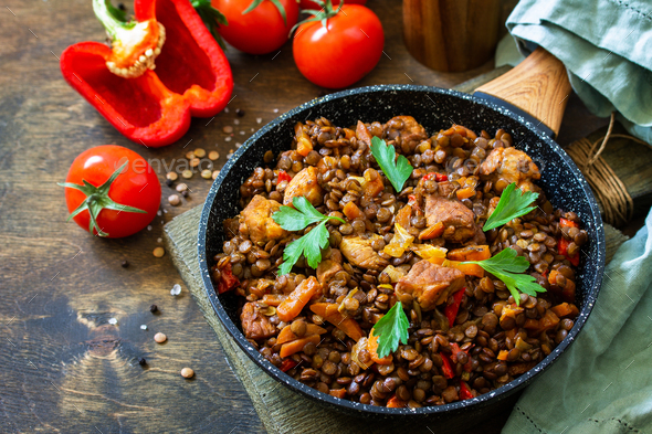 Traditional indian spicy green lentils with meat, spices, herbs in a cast-iron frying pan. - Stock Photo - Images