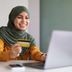 Online Payments. Smiling Muslim Woman In Hijab Using Laptop And Credit Card - PhotoDune Item for Sale