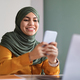 Smiling Arab Woman In Hijab Browsing App On Smartphone In Office - PhotoDune Item for Sale