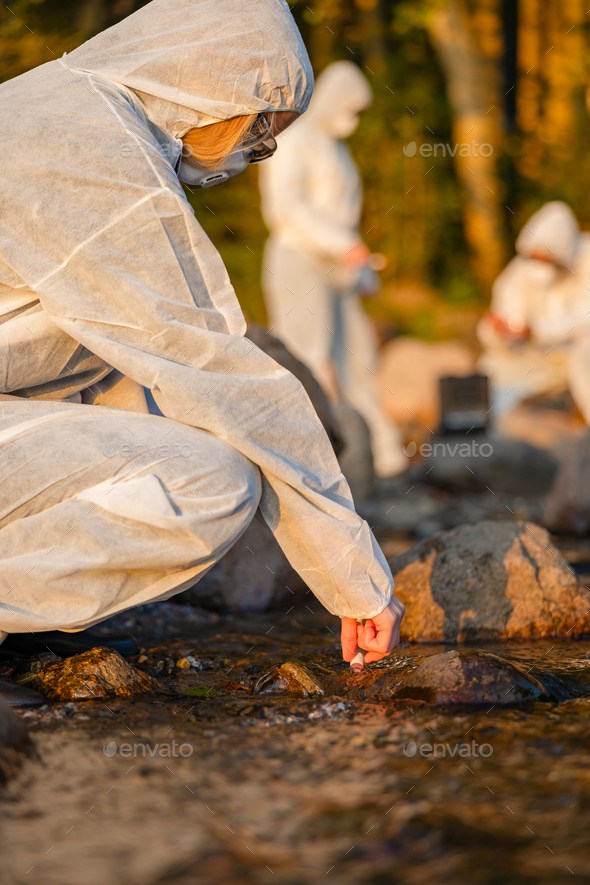 Close-up of female scientist collecting water sample from sea - Stock Photo - Images