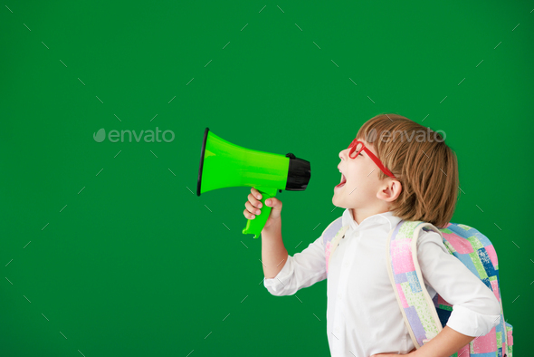 Happy child student against green chalkboard - Stock Photo - Images