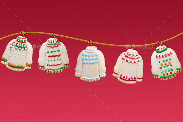 Ugly sweater Christmas cookies hanging on golden rope