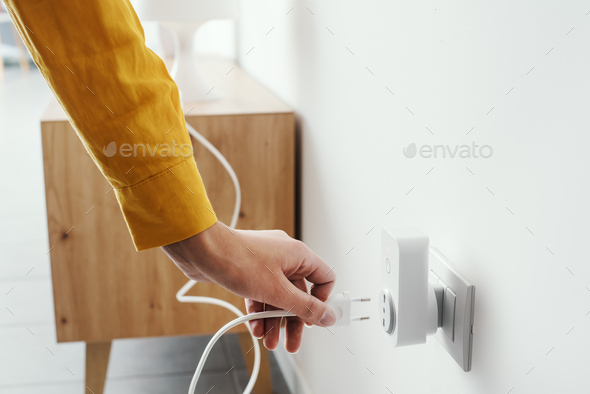Woman plugging a device into a smart plug