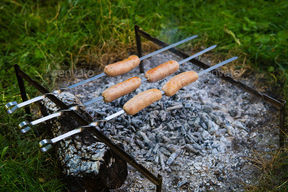 Fried sausages on skewers. Summer evenings near the fire, good weekend.