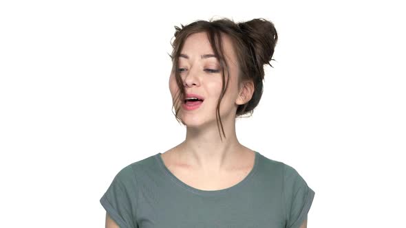 Portrait of Brunette Woman 20s with Double Buns Hairstyle Having Fun and Blowing Off Curl From Face alt