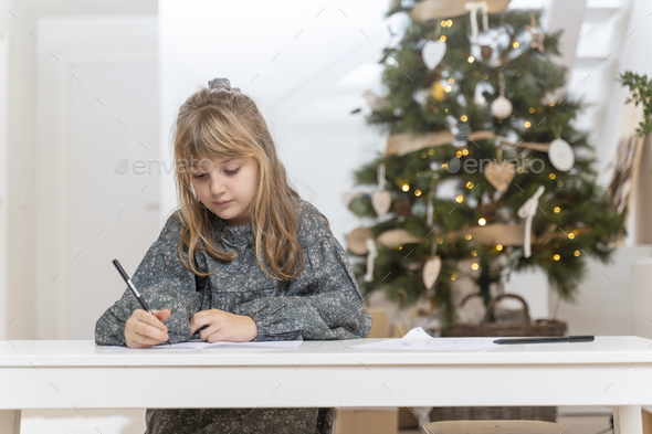 Little girl writing a letter to Santa Claus or the three wise men