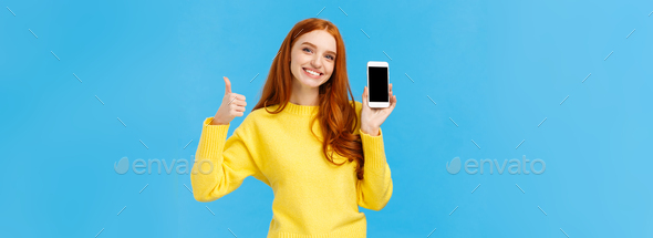 Girl showing good app, recommend download very useful application. Cute redhead woman in yellow - Stock Photo - Images