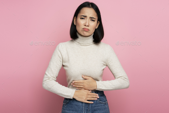 Portrait of woman clutching belly suffering stomach ache, gastritis or constipation