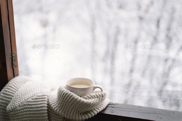 Cup of hot tea with a warm sweater on a vintage wooden windowsill - Stock Photo - Images