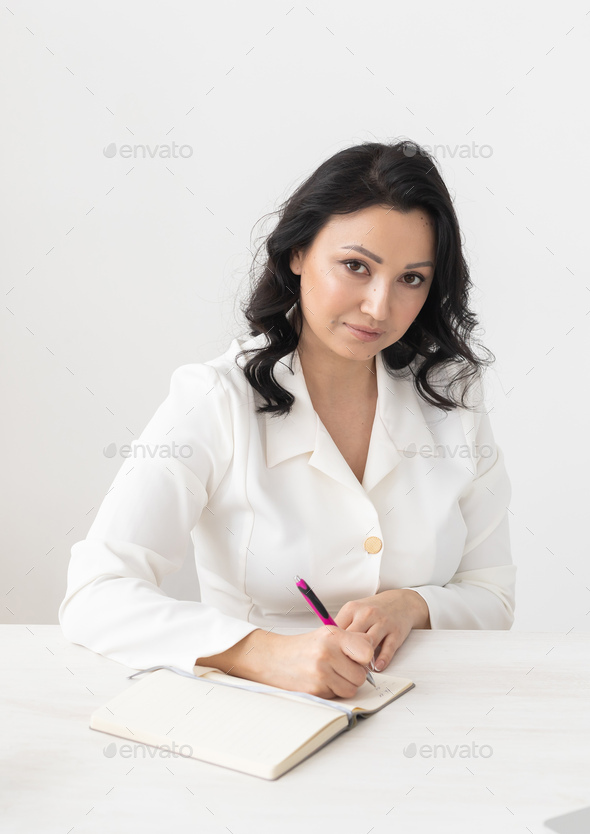 Indian woman beautician or doctor takes notes in office - cosmetologist business woman or doctor