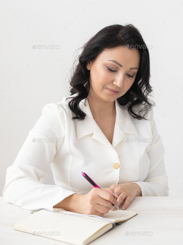 Portrait Indian woman beautician takes notes in office - cosmetologist business woman or doctor