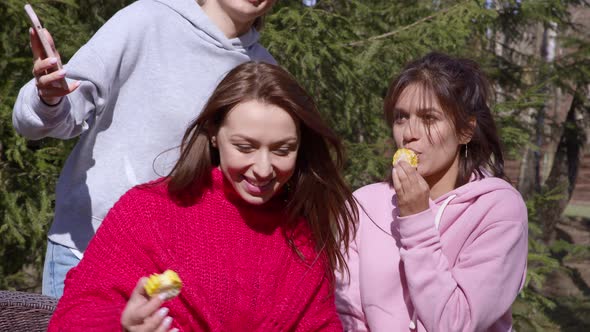 Young Girls Have Fun on a Picnic, Eat Corn and Take Selfies and Laugh.