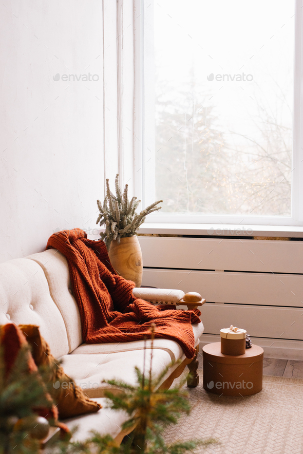Stylish Scandinavian living room with a sofa by the window, decorated