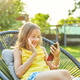 Happy kid girl holding smartphone having video call with friend distantly - PhotoDune Item for Sale