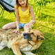 Cute girl and old dog enjoy summer day on the grass in the park - PhotoDune Item for Sale