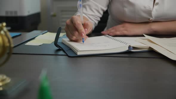 Young Female Doctor Writing Words in Notebook with Pen and Finishing with Dot alt