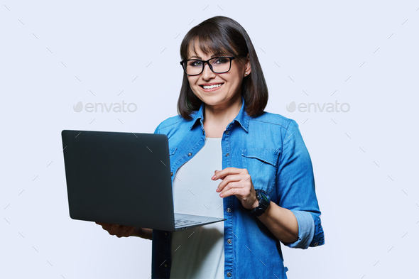 Mature business woman using laptop on white studio background - Stock Photo - Images