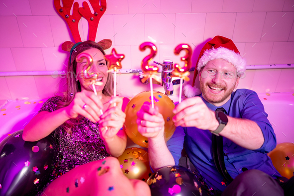 Couple having fun celebrating New Year at house party - Stock Photo - Images