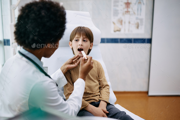 Little boy during throat examination at pediatrician's office.