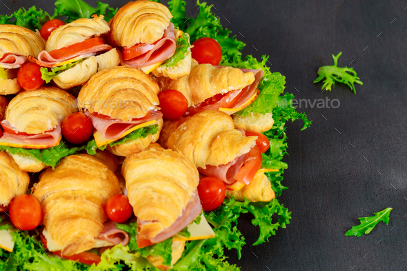 Tasty breakfast. Appetizing croissant with salami cheese and tomatoes