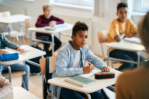 African American elementary student and his classmates during lecture ...