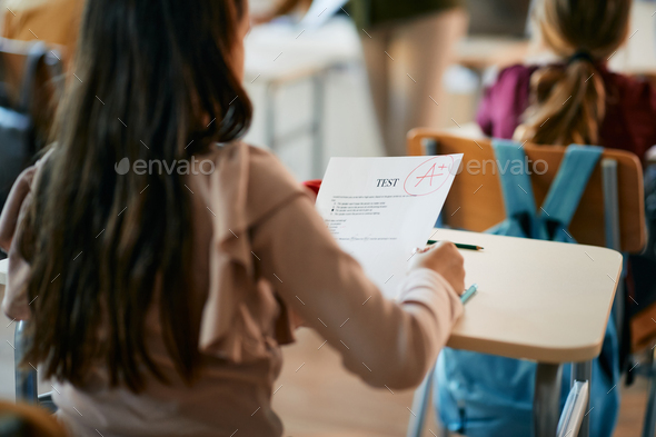 Cloe-up of schoolgirl getting A grade on a test at elementary school.