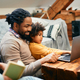 African American father having fun while surfing the net on laptop with his daughter at home. - PhotoDune Item for Sale