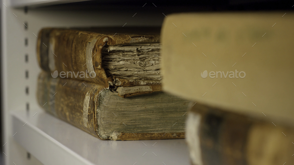 Expert takes an old book from the shelf. Stock footage. An ancient relic taken by gloved hands