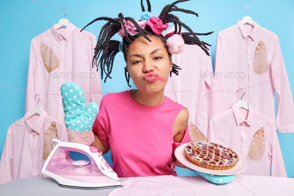 Funny housewife with braided hairstyle and leaked lipstick poses with delicious handmade pie busy