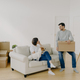 Positive woman and man pose in empty spacious room during relocation day - PhotoDune Item for Sale